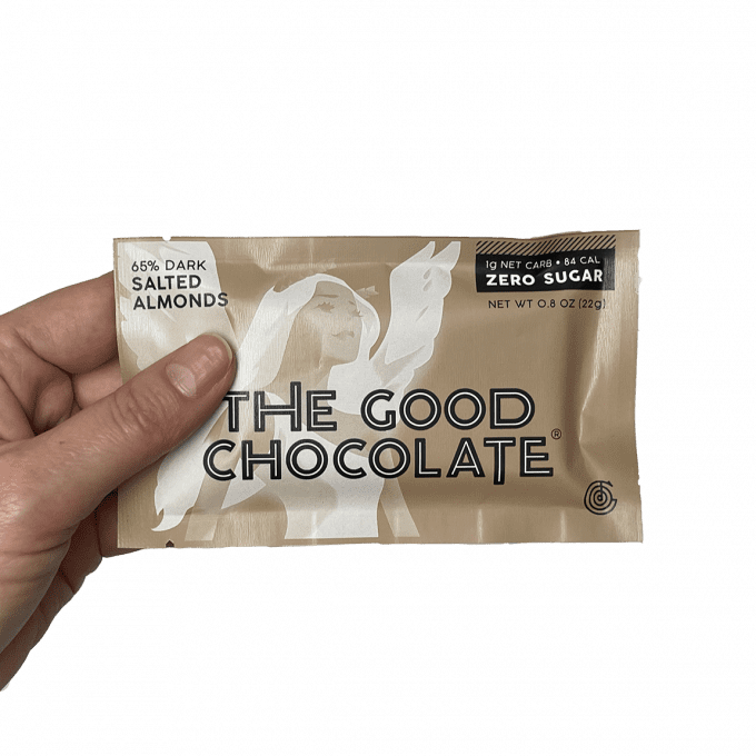 Someone holds the pack of The Good Chocolate's Salted Almonds Chocolate Mini Bar
