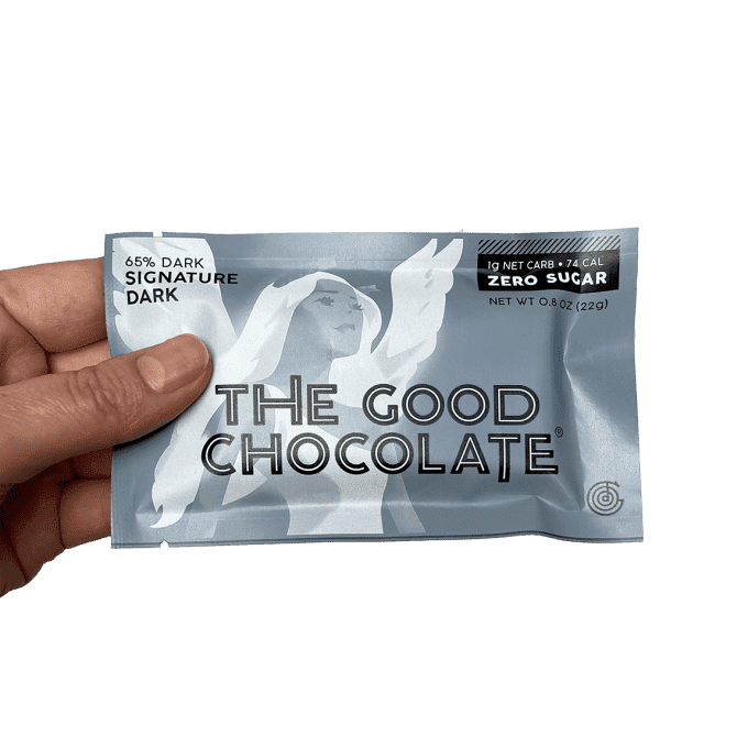 Someone holds the pack of The Good Chocolate's Signature Dark Chocolate Mini Bar