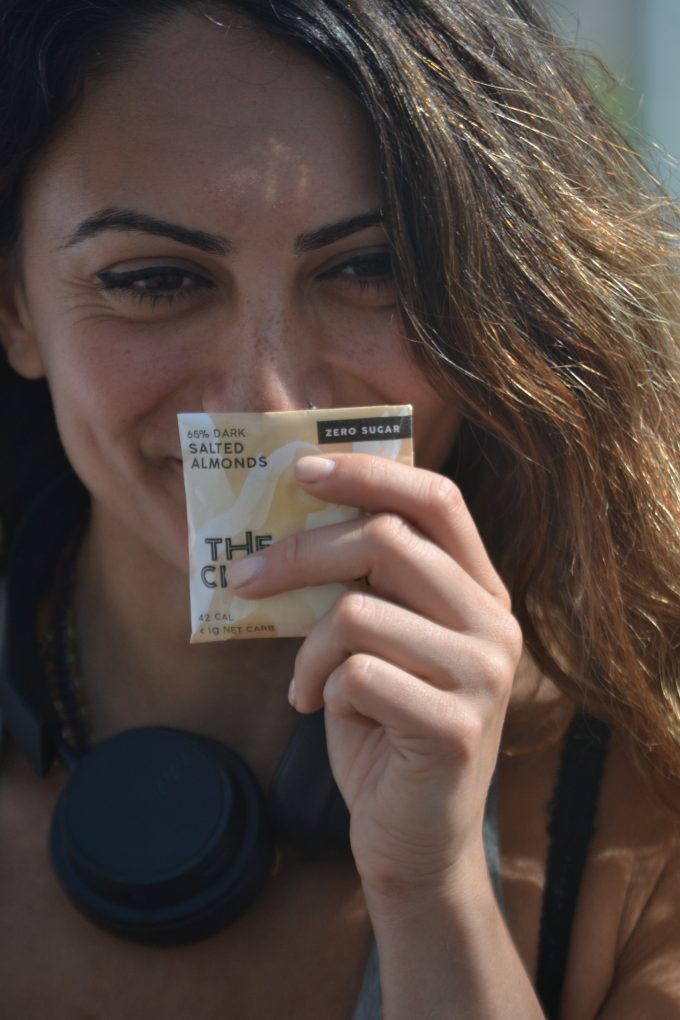 Woman Smiling and Showing The Good Chocolate's Salted Almond Square